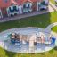 König Spielschiff mit Spiralrutsche auf einem Spielplatz inmitten von Grünflächen.
