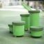 Spring Pflöcke (5 St.) als grün lackierte Sitzhocker auf einem Spielplatz mit rutschfesten Oberfläch