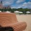Sofa Wave aus Holzlatten im Außenbereich auf Sand.