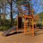 New Age Fit MEDIUM Spielplatzgerät mit oranger Kletterstruktur und Trainingsstation in naturverbunde