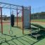 New Age Fit Outdoor-Fitnessstation mit Klettergerüst und Turnringen auf Sportplatz