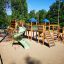 Weltraumstation mit Spieltürme und Spiralrutsche auf Sandspielplatz im Grünen