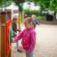 Kind spielt mit Uhr Spieltafel auf dem Spielplatz.