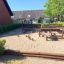 Fitness Anlage Holz-Spielplatz mit Balancier-Elementen und Sandboden im Freien.