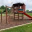 Spielturm mit Klappbrücke aus Holz mit Rutsche und Klettergerüst auf Spielplatz