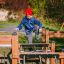 Kleine Fitnessanlage mit Holzbrücke und Kletterelementen für Kinder auf dem Spielplatz.