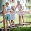 Kinder spielen auf der Bewegliche Brücke aus Holz auf dem Spielplatz.
