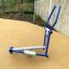 Blau-graue Cross Trainer Fitnessgerät für draussen mit Pedalen und Griffen auf Spielplatzboden.